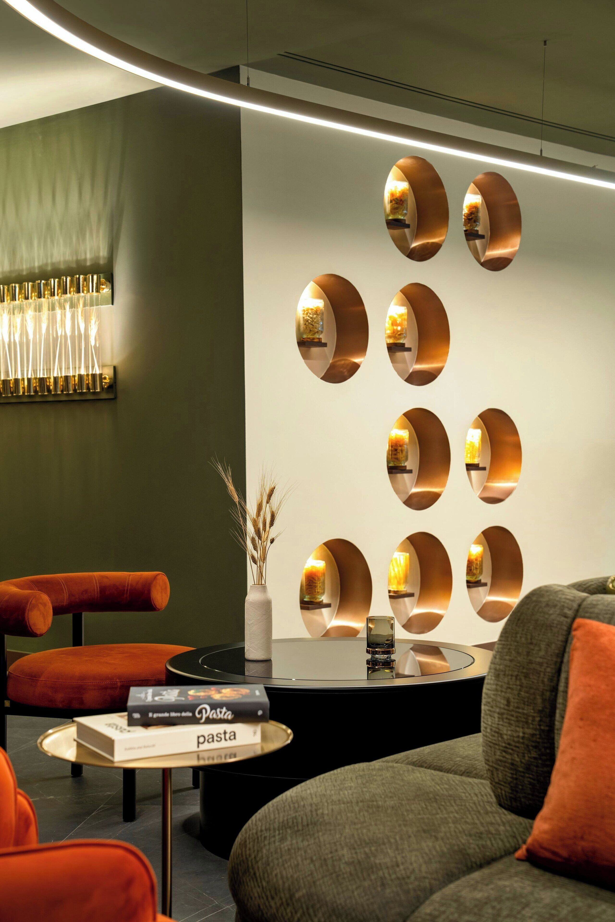 Un interior moderno con un sofá, una mesa de centro y un aplique de pared.