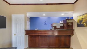 A reception desk with a blue wall and a wooden counter. - Best Western Fairwinds Inn (Cullman)