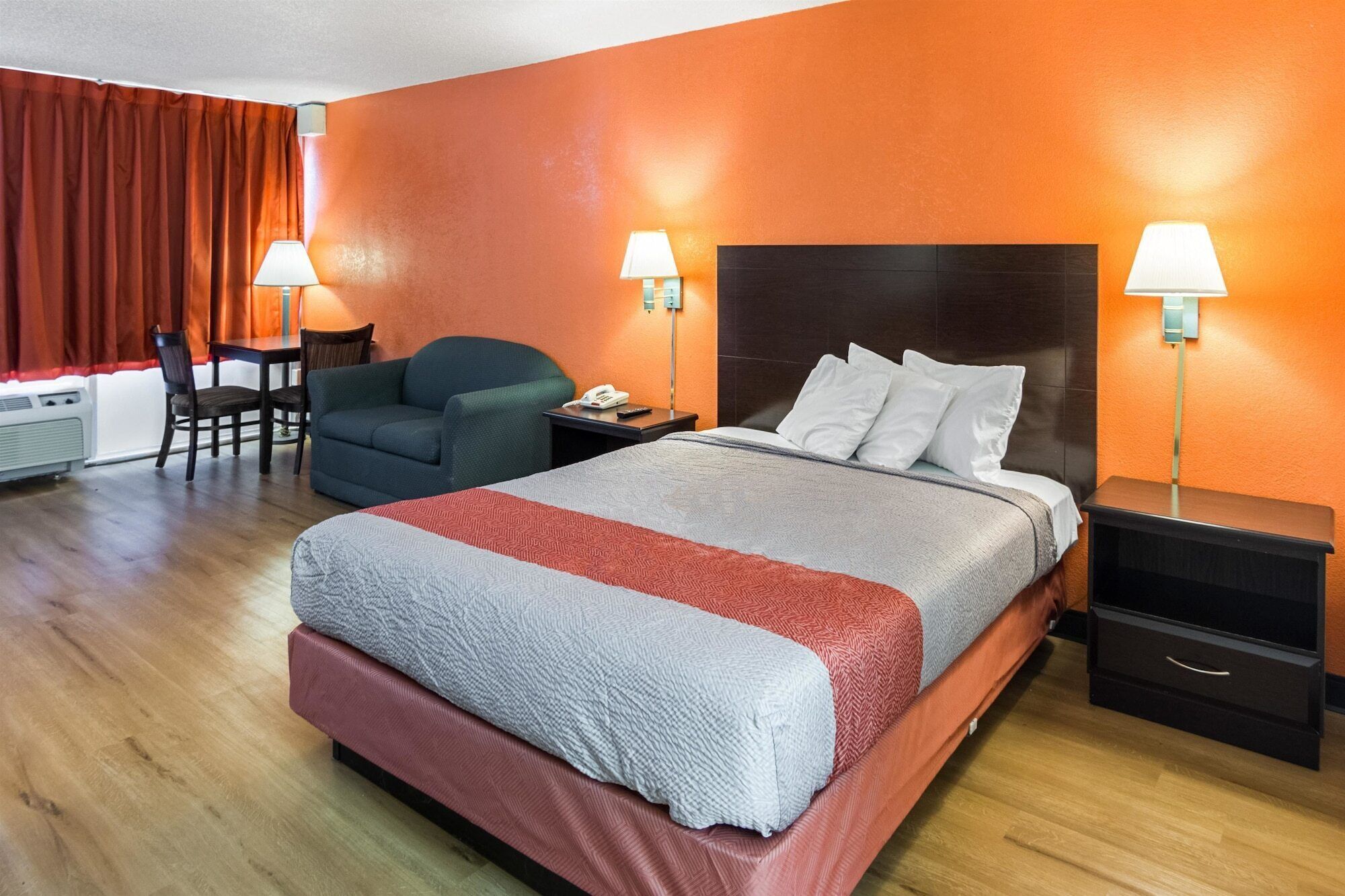 Habitación de hotel con una cama grande, dos mesitas de noche, un escritorio y una silla.