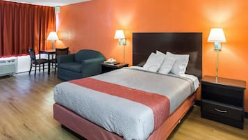 Habitación de hotel con una cama grande, dos mesitas de noche, un escritorio y una silla.