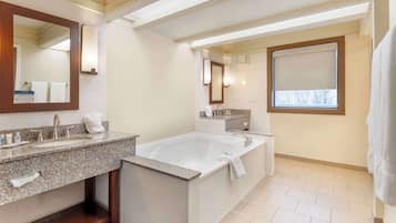 Un baño moderno con una bañera grande, dos lavamanos y un tocador.