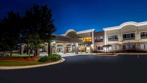 A hotel with a covered entrance, multiple floors, and a parking area. - Days Inn & Suites by Wyndham Rochester Hills MI (Rochester)