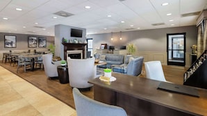 Un moderno vestíbulo de hotel con mostrador de recepción, zona de estar y comedor.