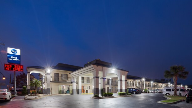 A hotel with a modern design, multiple floors, and a parking lot. - Best Western Inn (Florence)