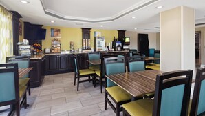 A restaurant with a bar area, seating, and a kitchen visible in the background. - Best Western Inn (Florence)