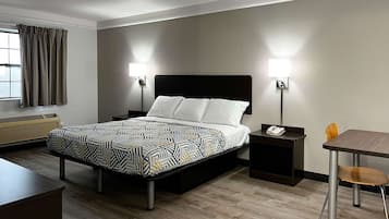 A hotel room with a bed, bedside tables, a desk, and a chair.