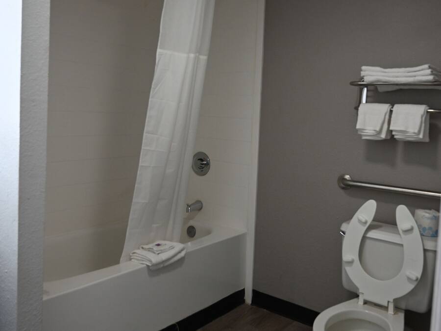 A bathroom with a bathtub, toilet, and towel rack.