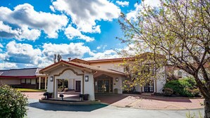 A two-story house with a tiled roof, a covered porch, and a driveway leading to the entrance. - Motel 6 Hazelwood, MO (Hazelwood)