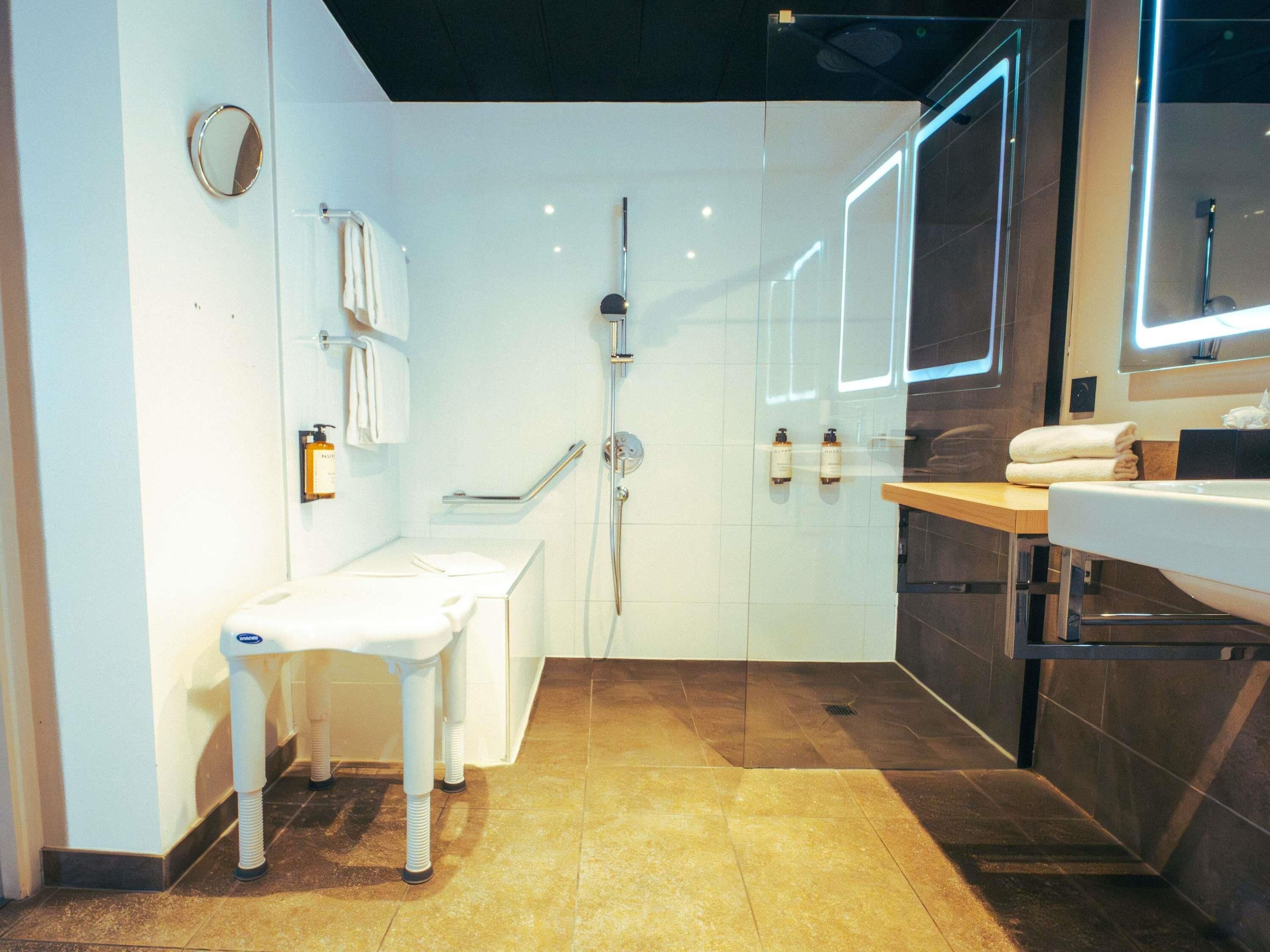 A modern bathroom with a shower, toilet, and sink.