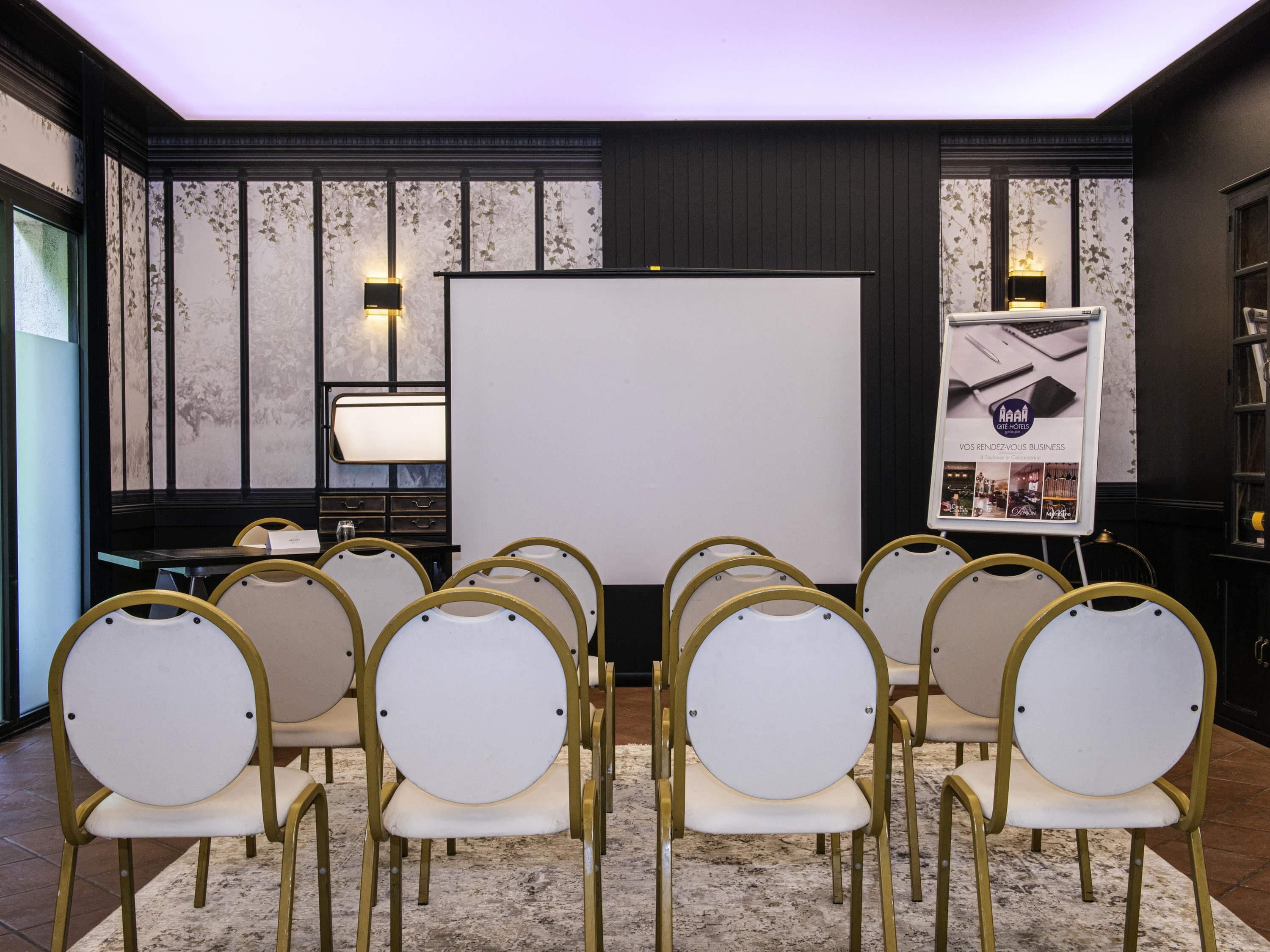 A conference room with a whiteboard, a projector, and a presentation board.