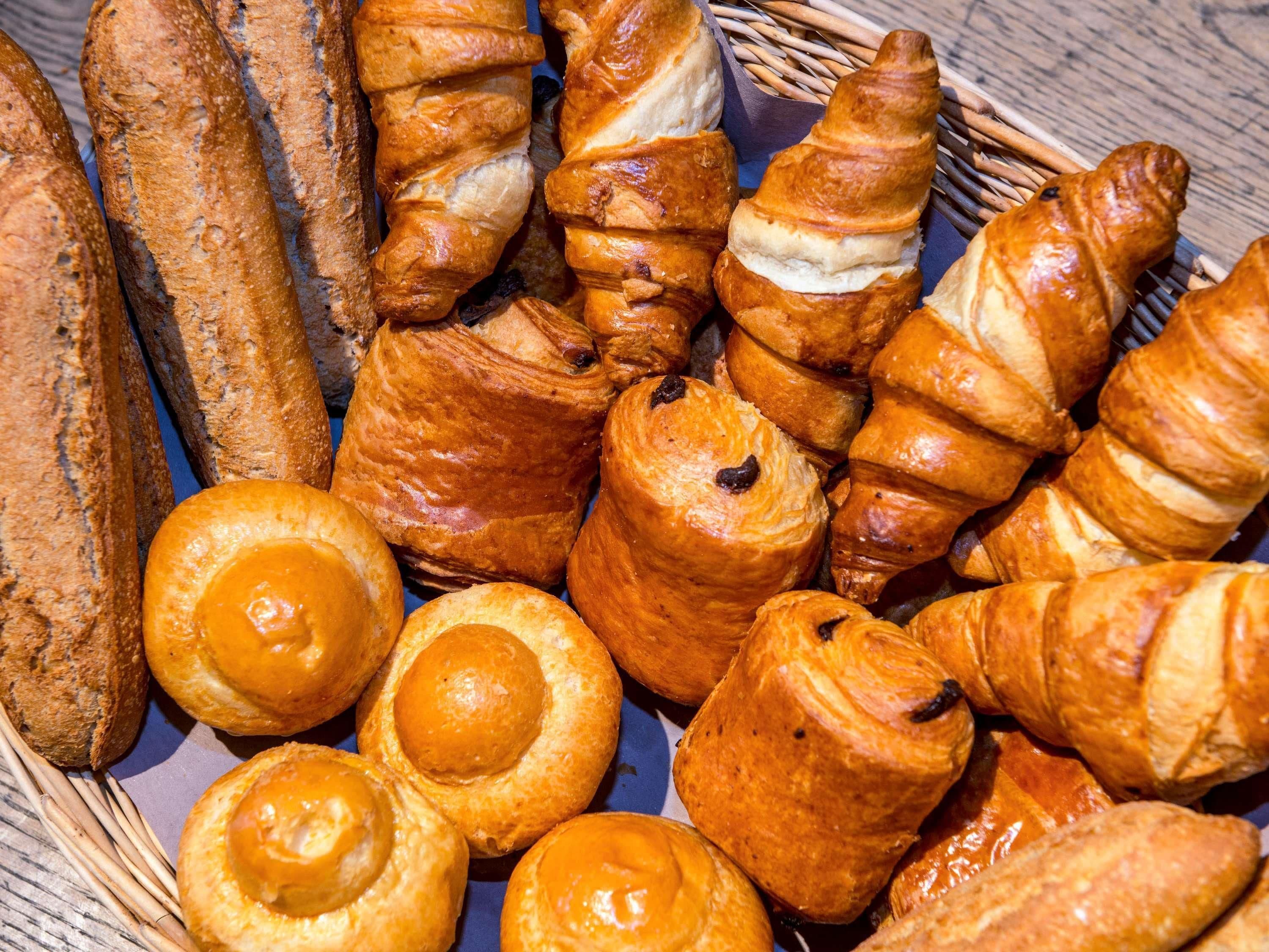 Variedad de productos horneados, incluyendo pan, croissants y bollos.
