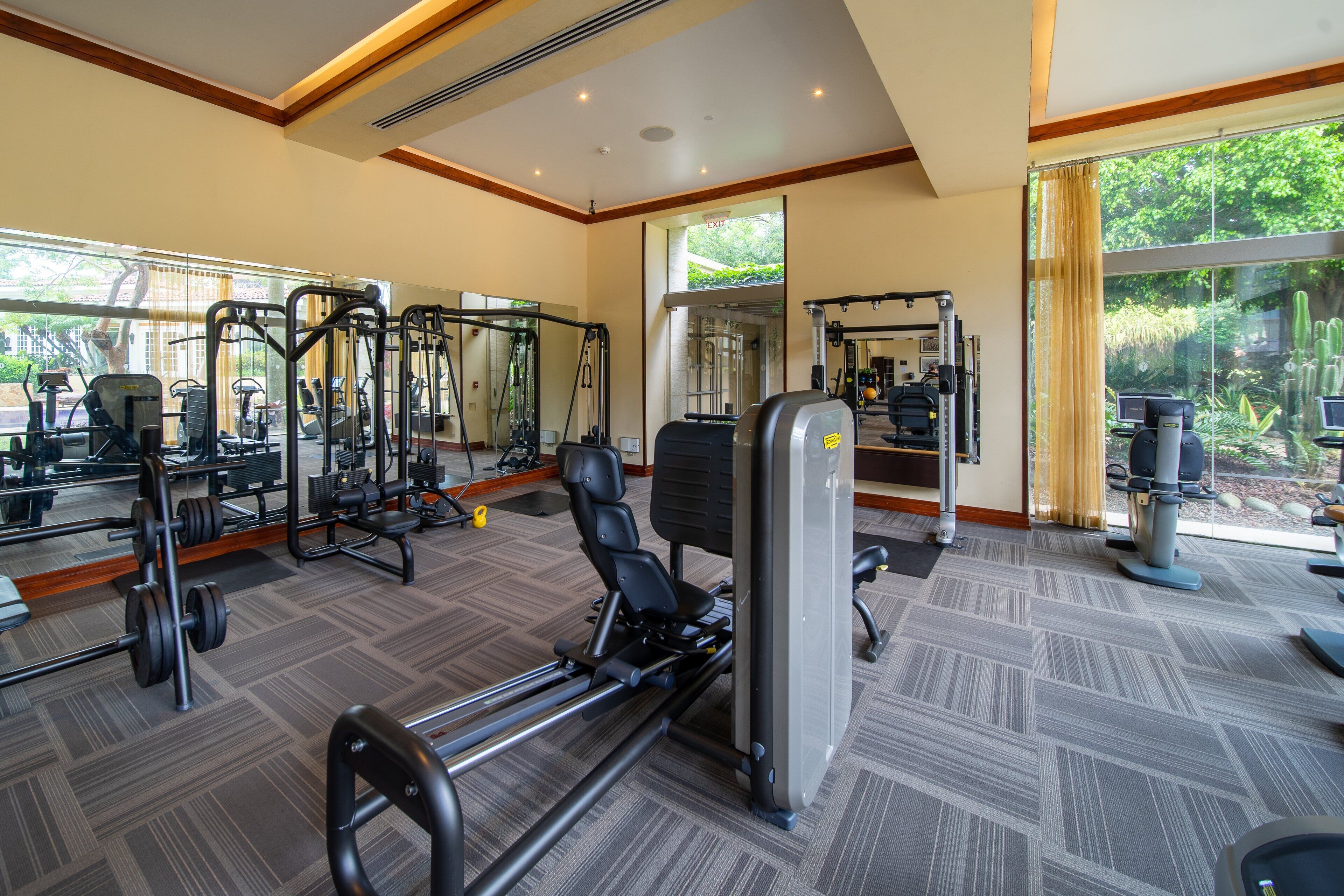 A gym with cardio machines, weight stations, and mirrors.