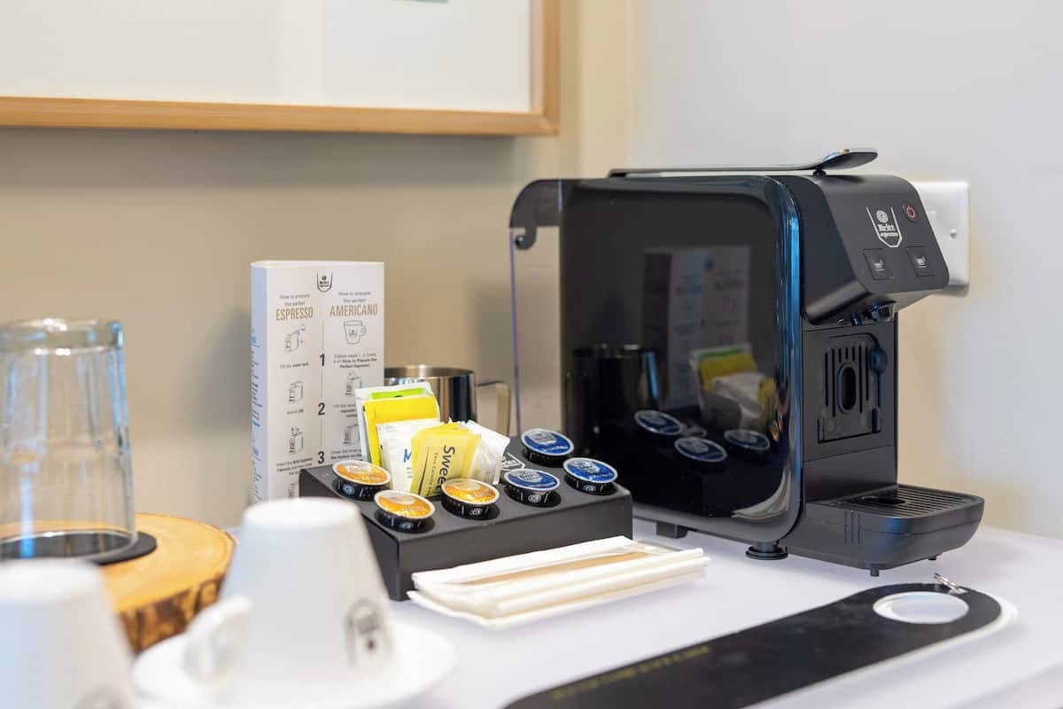 A coffee machine with various coffee pods and a menu on the counter.