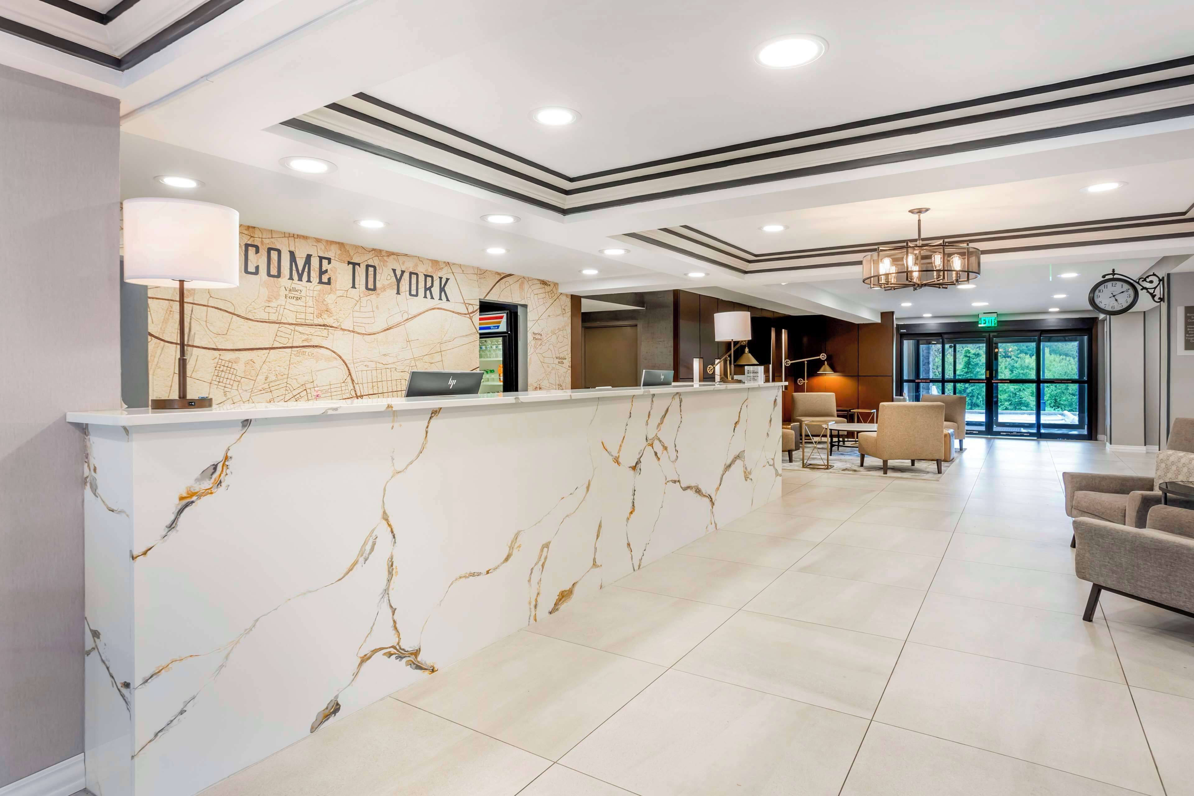A reception area with a marble counter, a map, and a clock on the wall.