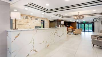 A reception area with a marble counter, a map, and a clock on the wall.