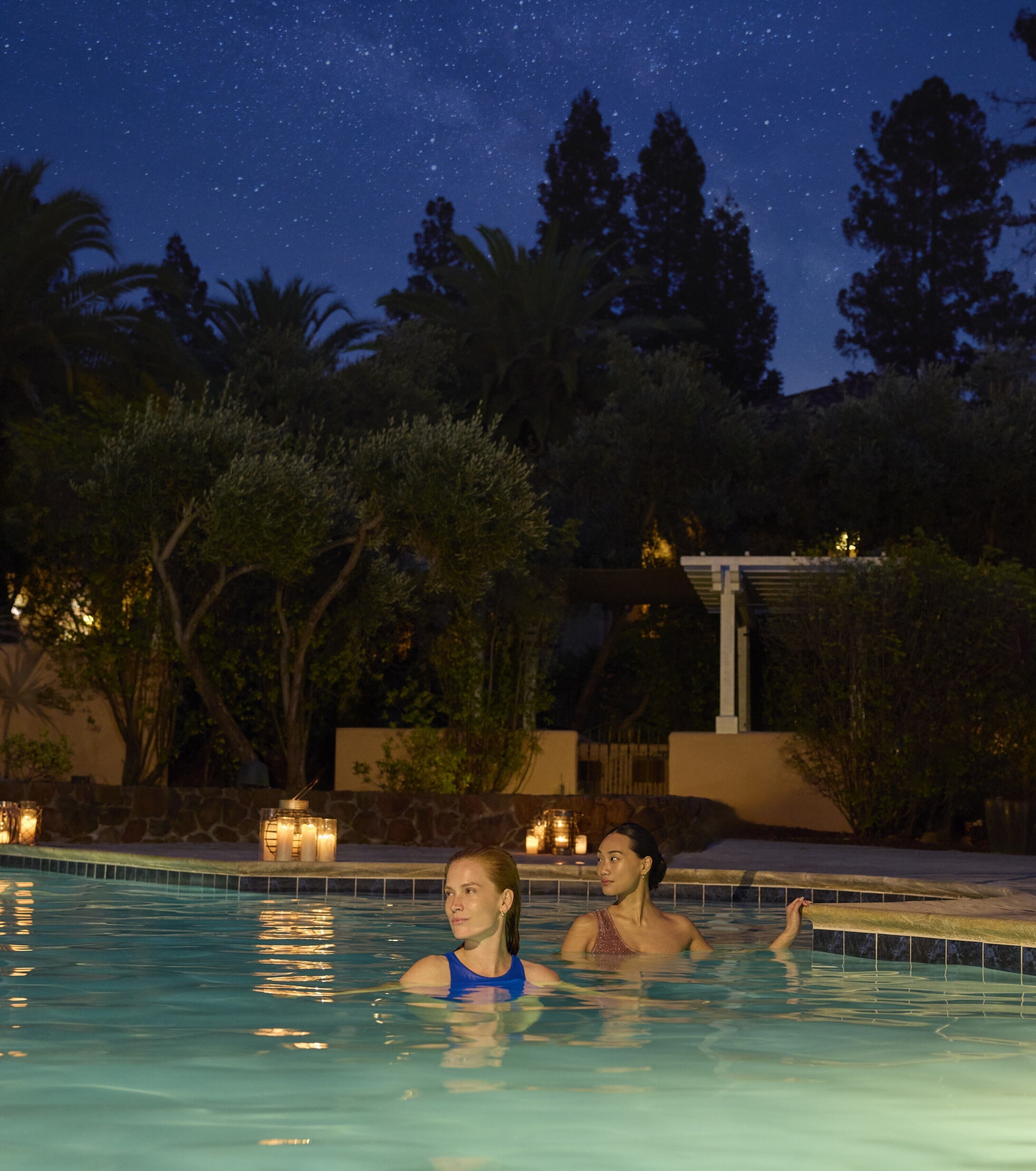 A swimming pool at night with a starry sky.