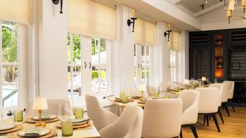 A dining area with multiple tables, chairs, and a view of the outdoors.