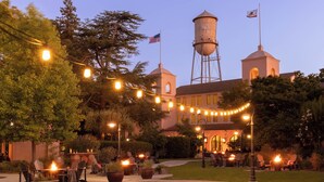 A historic building with a water tower, outdoor seating area, and string lights. - Fairmont Sonoma Mission Inn & Spa (Sonoma)