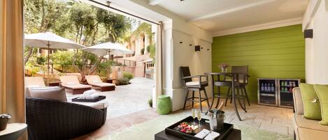 Un vaste patio doté d’un espace salon extérieur, d’un ventilateur de plafond et d’un mur d’accent de couleur verte.