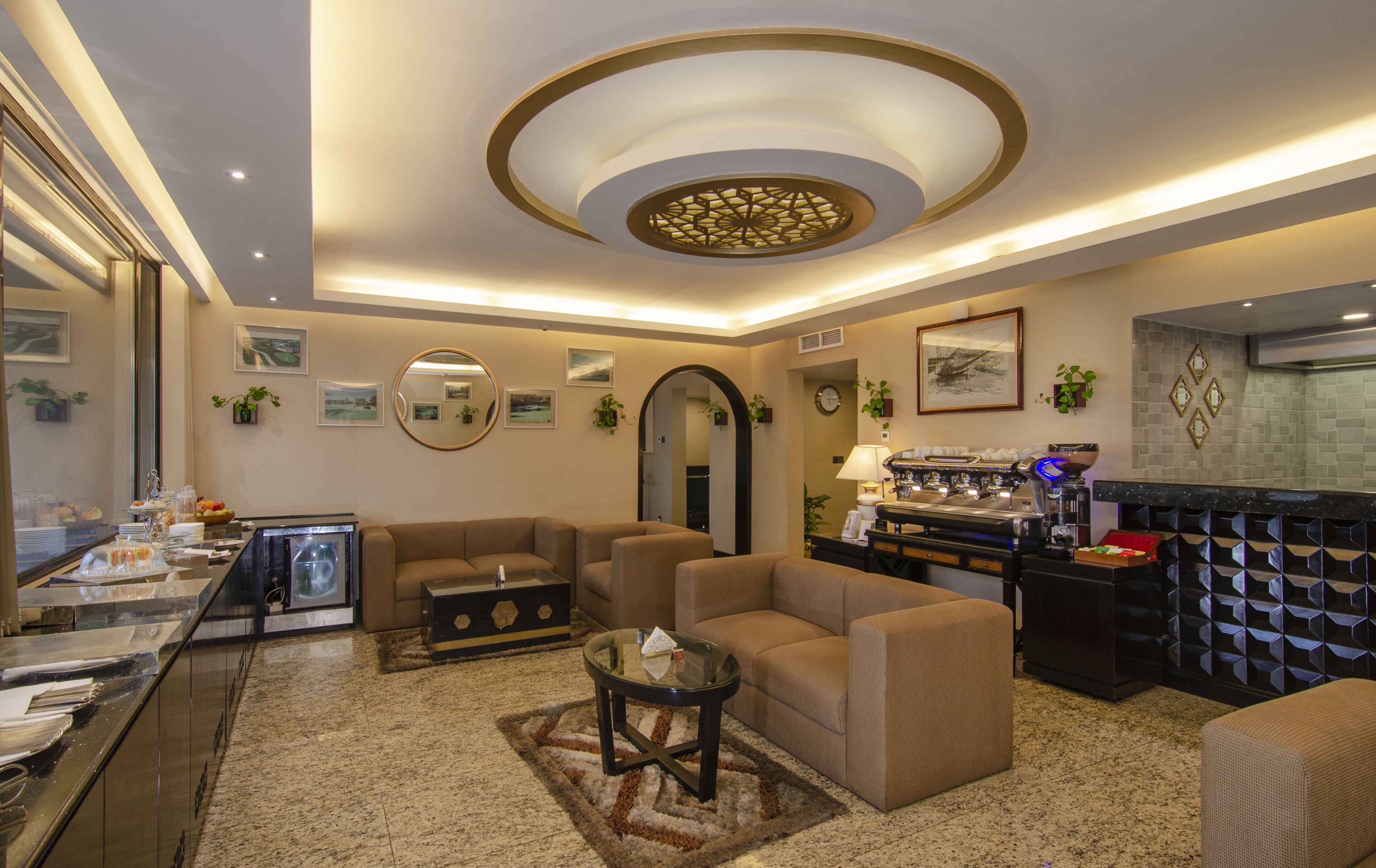 A modern hotel lobby with a seating area, a coffee station, and a buffet.