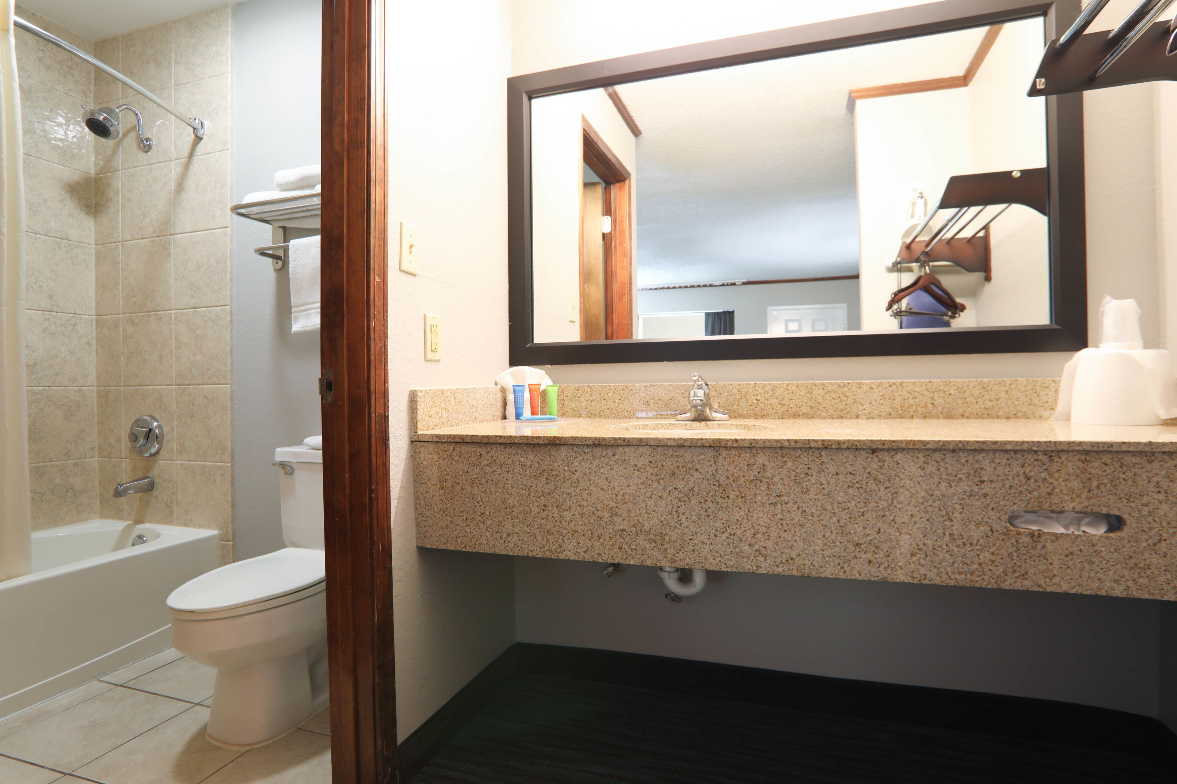 Une salle de bain avec une baignoire, des toilettes, un lavabo et un miroir.