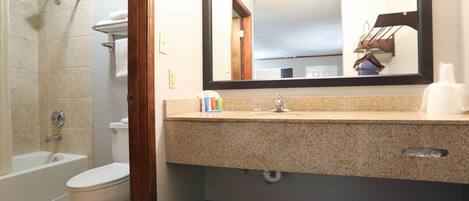 Une salle de bain avec une baignoire, des toilettes, un lavabo et un miroir.