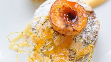 Een nagerechtopstelling met een bolvormig dessert en gekaramelliseerd fruit.