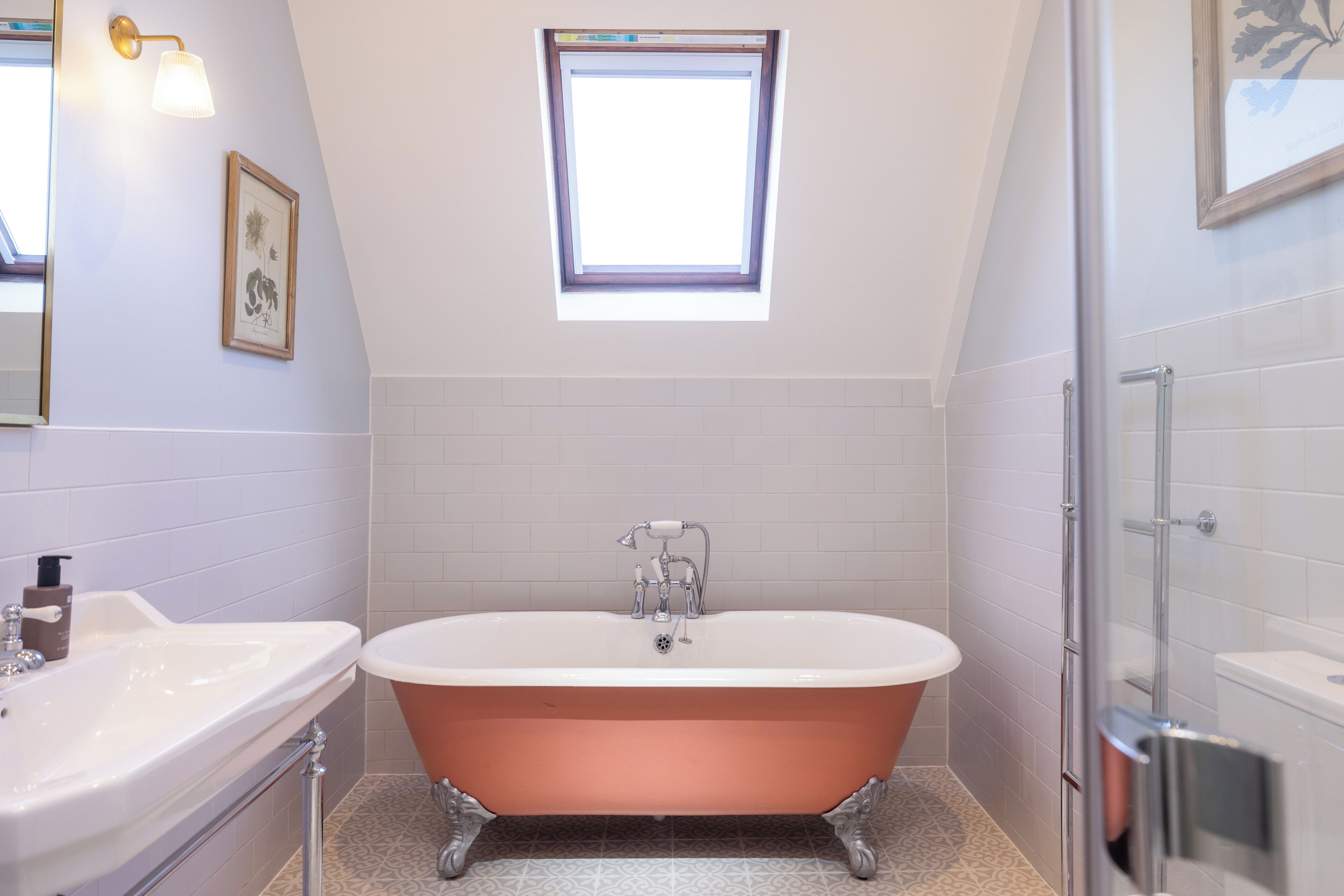 A bathroom with a freestanding bathtub, a sink, and a shower area.