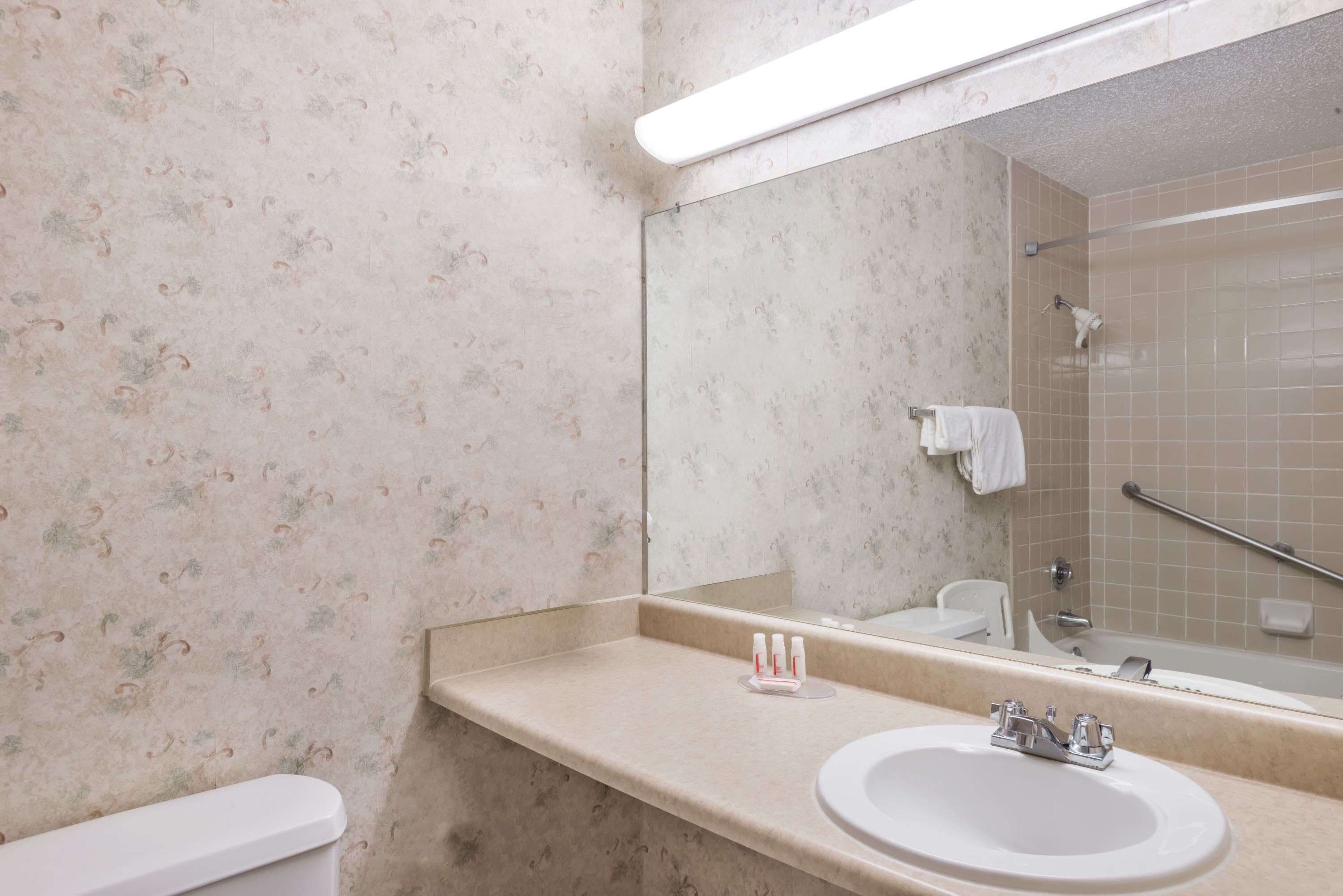 Un baño con inodoro, lavamanos y ducha.