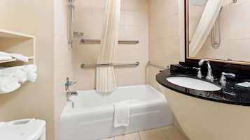 A bathroom with a bathtub, a sink, a mirror, and a towel rack.