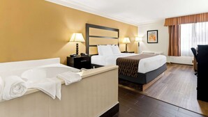 A hotel room with two beds, a bathtub, and a desk. - Best Western Riverside Inn (Macon)