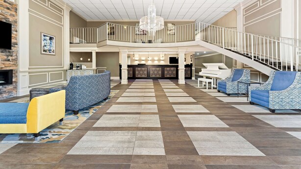 A spacious lobby with a checkered floor, a staircase, and seating areas. - Best Western Riverside Inn (Macon)