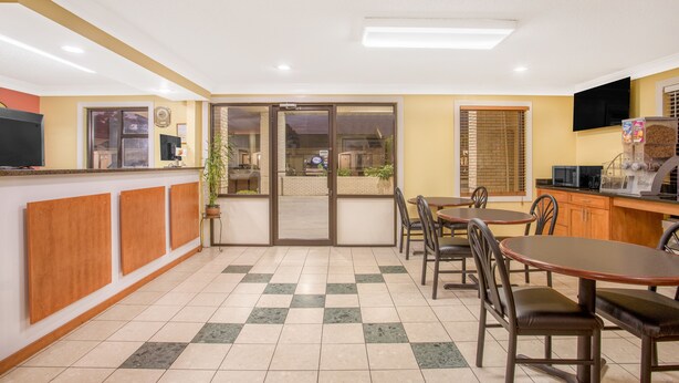 Un restaurant avec un comptoir, un espace pour s’asseoir et une vue à travers les portes vitrées.