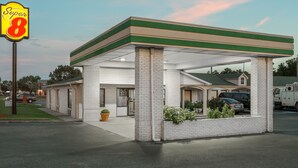 Un motel de type Super 8 doté d’un toit végétalisé, d’une façade en briques blanches et d’un espace de stationnement couvert.