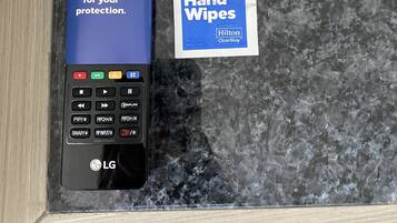 Un control remoto con la marca Hilton CleanStay y un paquete de toallitas húmedas.