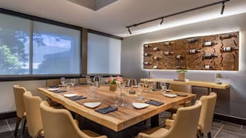 Un espace repas moderne avec une grande table en bois, dressée pour six personnes, entourée de chaises de couleur beige.