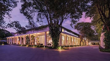 A convention center with a modern architectural design, featuring large glass windows and a well-lit entrance.