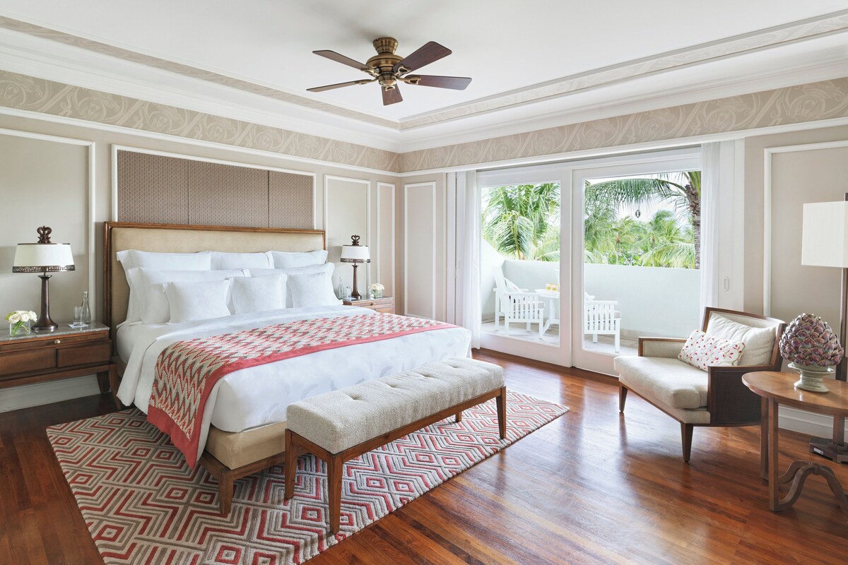 A spacious bedroom with a large bed, a ceiling fan, and a view of the outdoors.