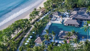 An aerial view of a resort with a swimming pool, beach, and palm trees. - InterContinental Bali Resort by IHG (Jimbaran)