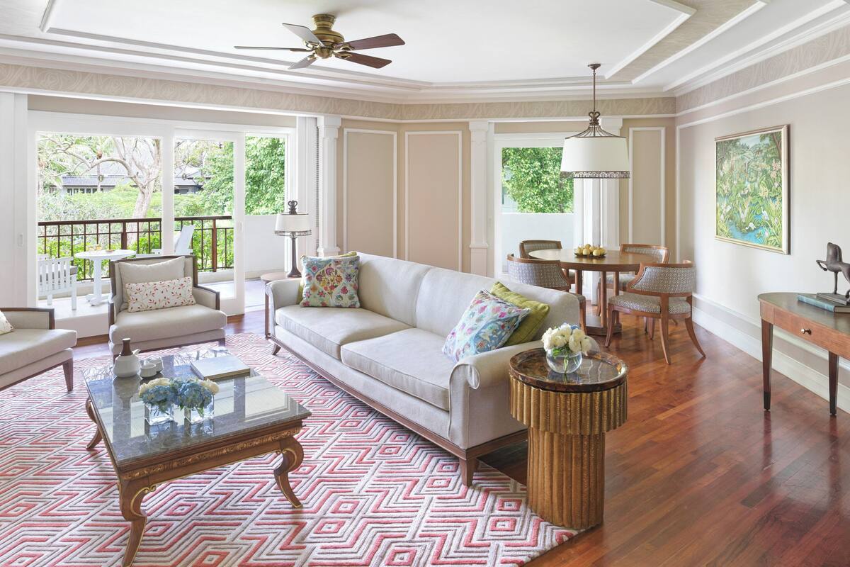 A spacious living room with a sofa, armchairs, a coffee table, and a dining area with a table and chairs.