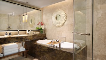 Une salle de bain moderne dotée d’un grand miroir, de deux vasques, d’une douche à parois de verre et d’un comptoir en marbre.