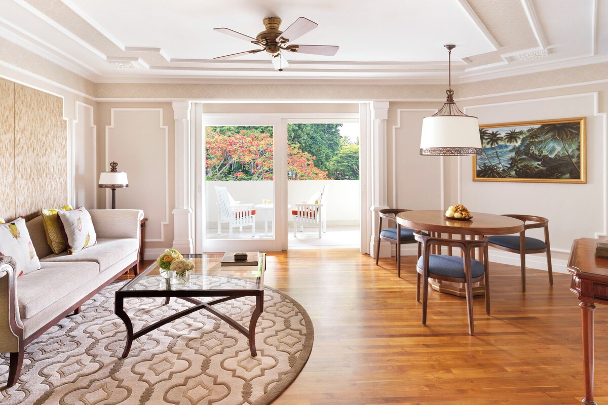 A spacious living room with a sofa, coffee table, and dining area.