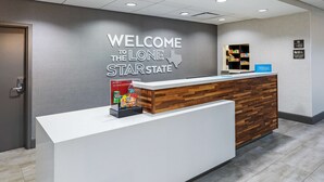 A hotel reception desk with a welcome sign, a minibar, and a sign indicating the hotel is part of the Lone Star State chain. - Hampton Inn & Suites Houston Heights I-10 (Houston)