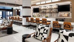 A modern bar area with multiple seating options, a large pillar, and a television screen. - Hyatt Regency San Francisco Downtown SOMA    (San Francisco)
