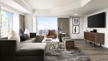 A modern living room with a sofa, armchairs, a coffee table, and a TV.