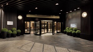 A hotel entrance with a revolving door, potted plants, and a sign for the Hyatt Regency. - Hyatt Regency San Francisco Downtown SOMA    (San Francisco)