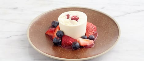 A dessert on a plate with strawberries and blueberries.