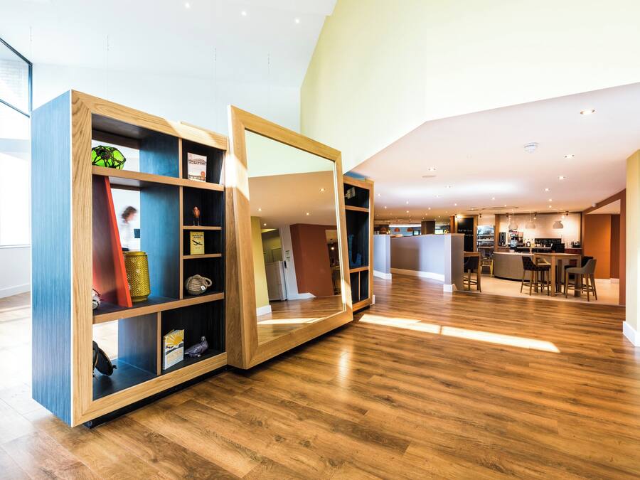 Un interior modern amb terres de fusta, una zona de cuina i un espai per seure.