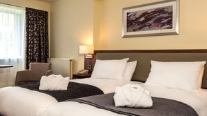 A hotel room with two beds, a chair, a lamp, and a painting on the wall. - Holiday Inn Lancaster by IHG (Lancaster)