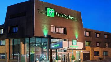 A Holiday Inn hotel with a reception desk, a car park sign, and a sign for the restaurant.